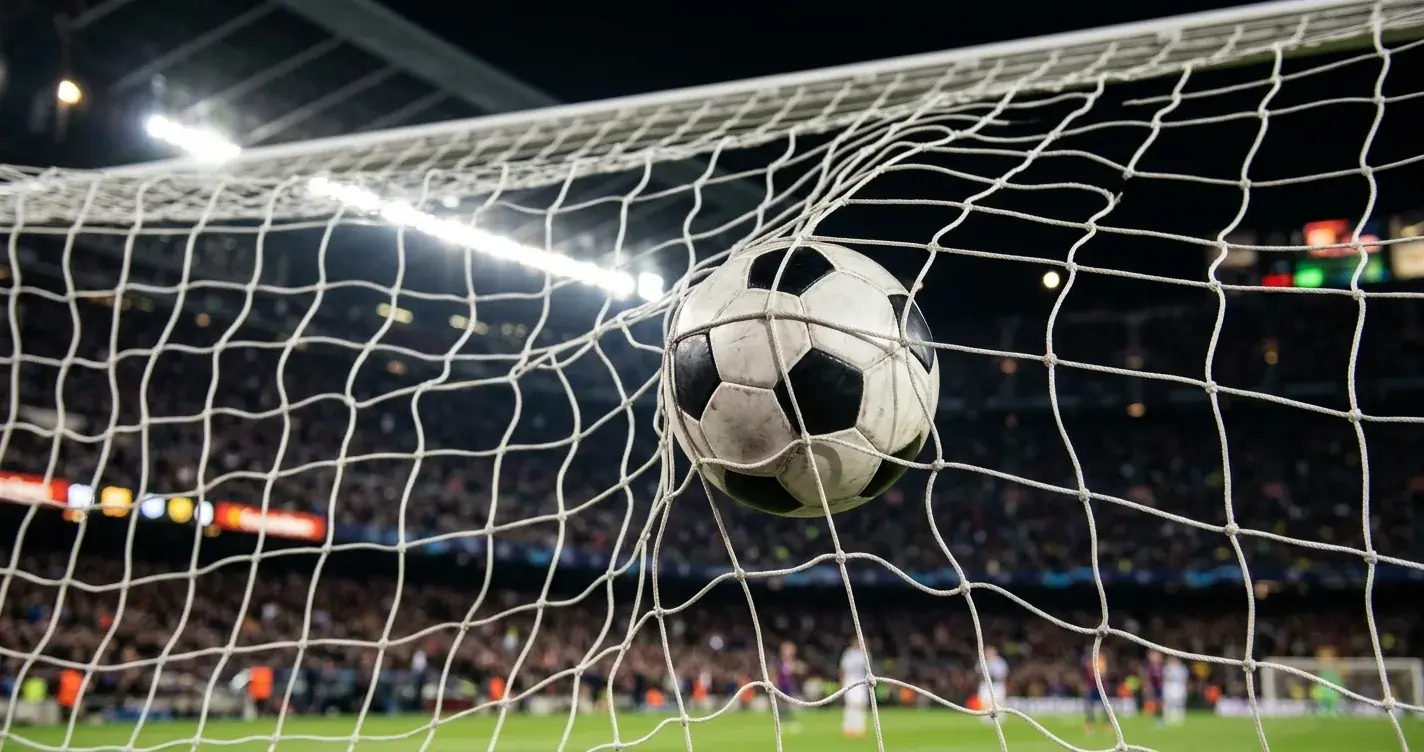 Fussball im Tornetz mit Flutlicht im Hintergrund